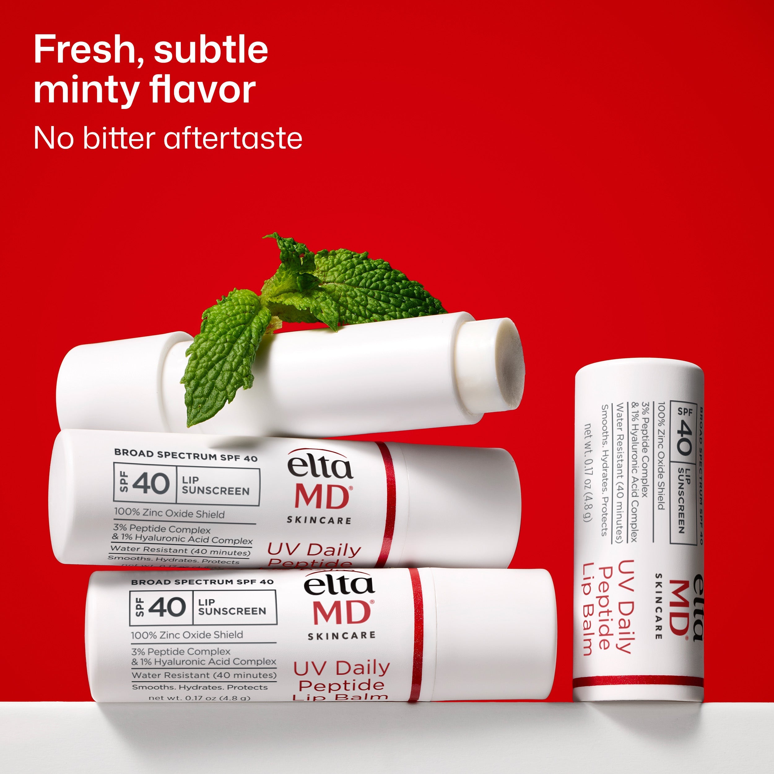 Ella MD lip balm tubes with mint leaves on a red background